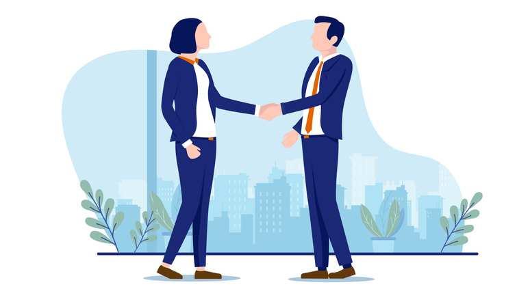 A man and woman in blue suits shake hands